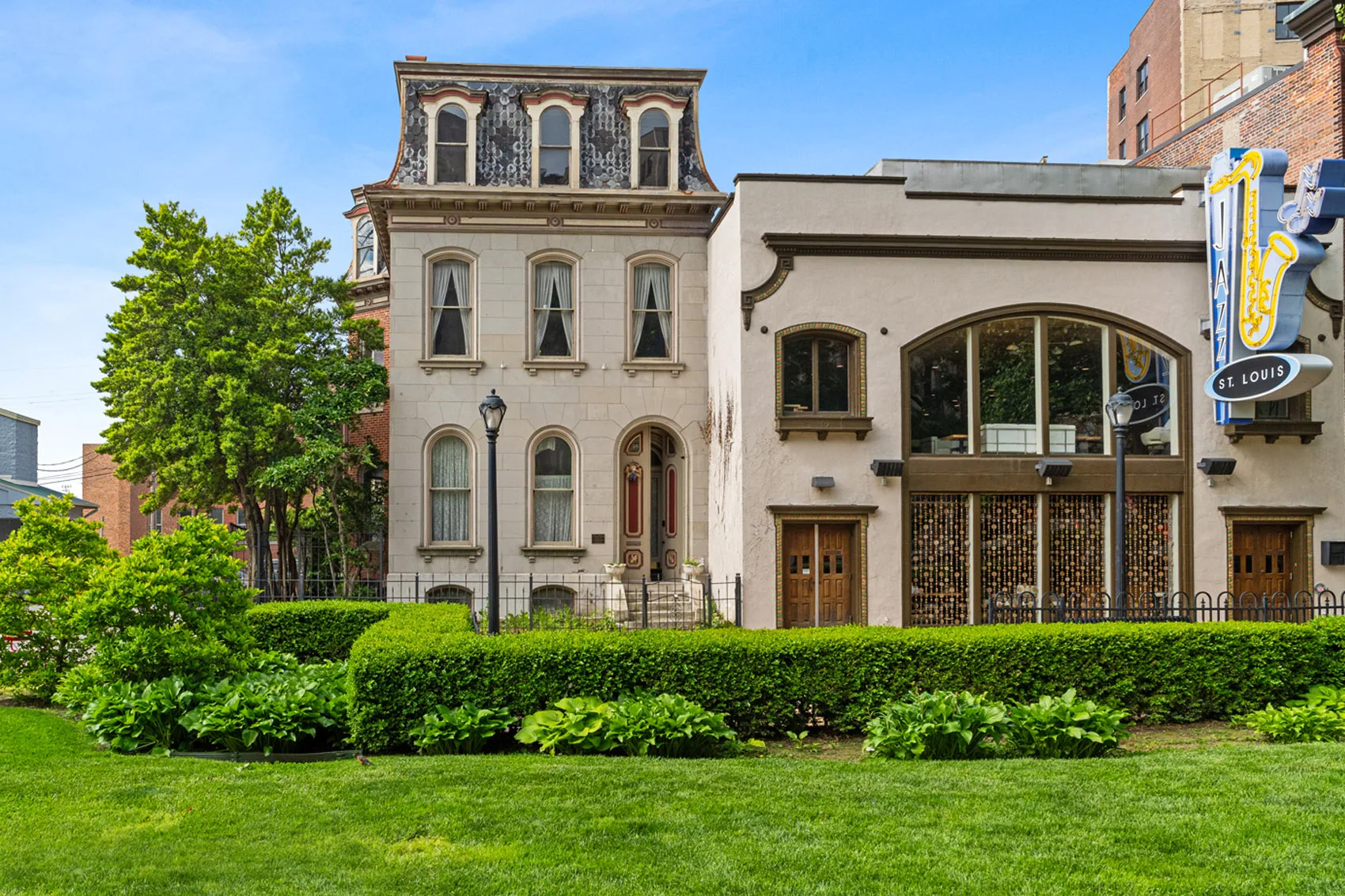 Front of the historic mansion at 3534 Washington Avenue, with its mansard roof, arched windows, and landscaped grounds beside Jazz St. Louis