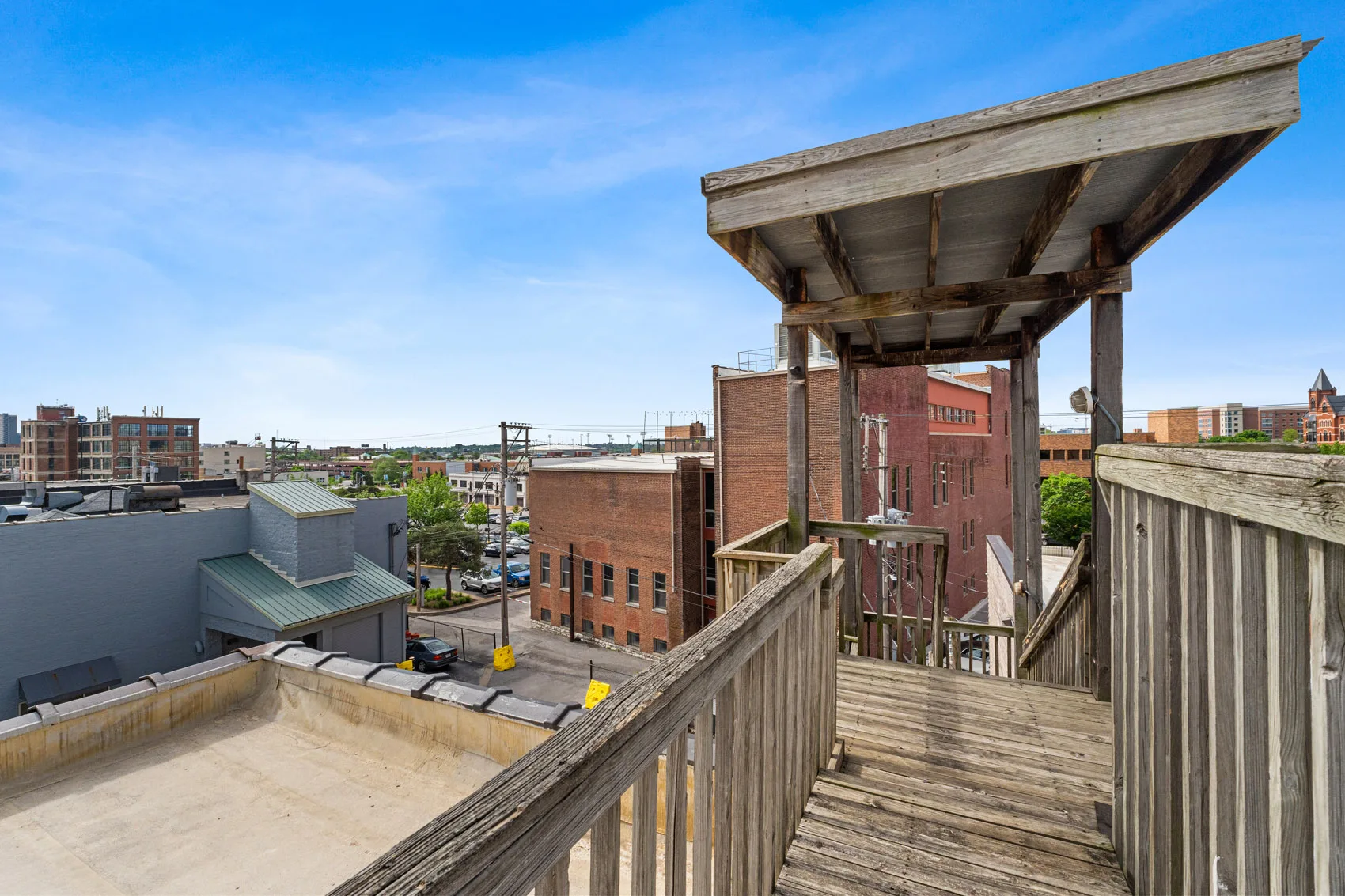 Wooden rooftop stairs and railing overlooking brick buildings in St. Louis' Grand Center district